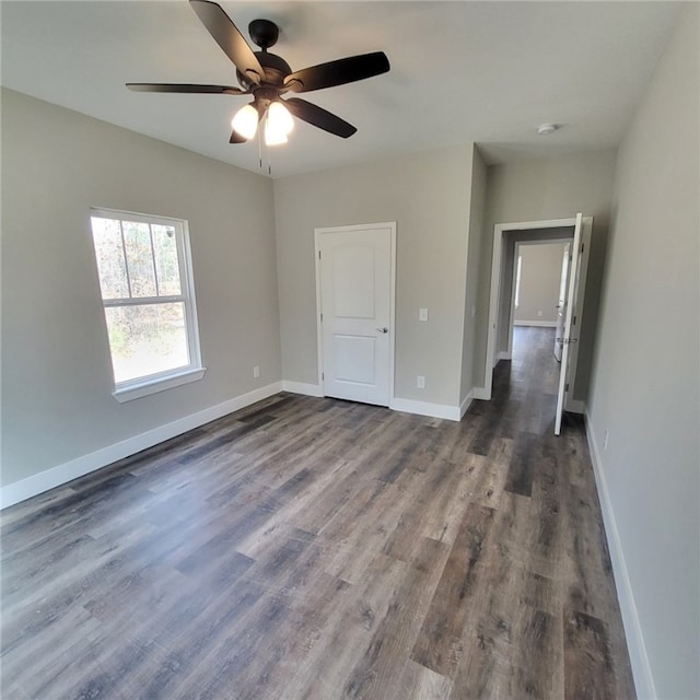 unfurnished bedroom featuring dark wood-type flooring and ceiling fan