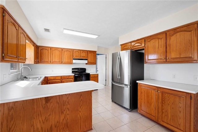 kitchen with sink, light tile patterned floors, stainless steel refrigerator, kitchen peninsula, and black range with electric stovetop