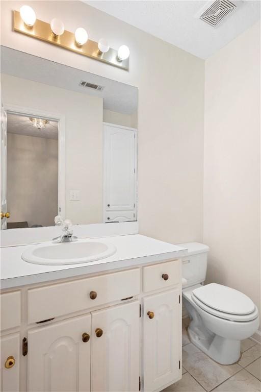 bathroom featuring tile patterned flooring, vanity, and toilet