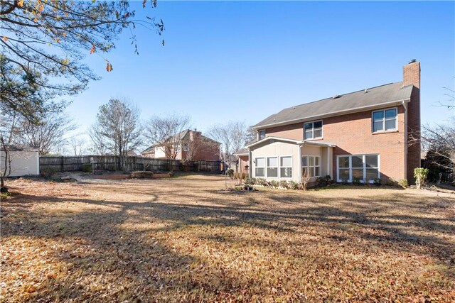 605 Lockwood St, Auburn, AL 36830 - back of house featuring fence, a lawn, and a chimney
