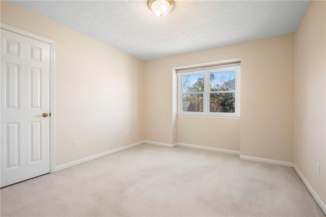 carpeted empty room featuring a textured ceiling