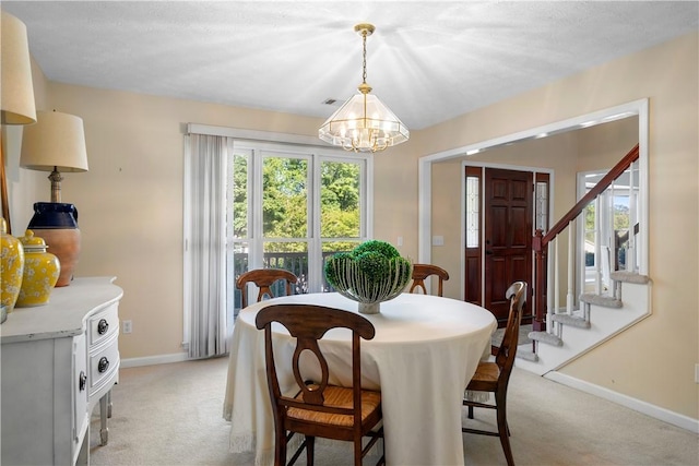 605 Lockwood St, Auburn, AL 36830 - dining room featuring baseboards, a chandelier, light carpet, stairs, and visible vents