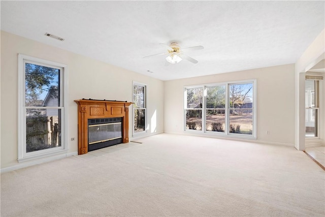 unfurnished living room featuring ceiling fan and light colored carpet