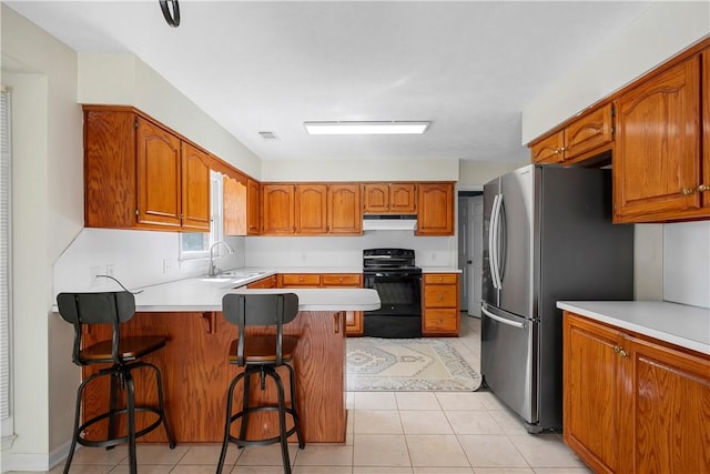 605 Lockwood St, Auburn, AL 36830 - kitchen with a sink, freestanding refrigerator, a peninsula, under cabinet range hood, and black range with electric stovetop