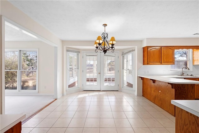 kitchen featuring pendant lighting, light tile patterned flooring, sink, and a textured ceiling