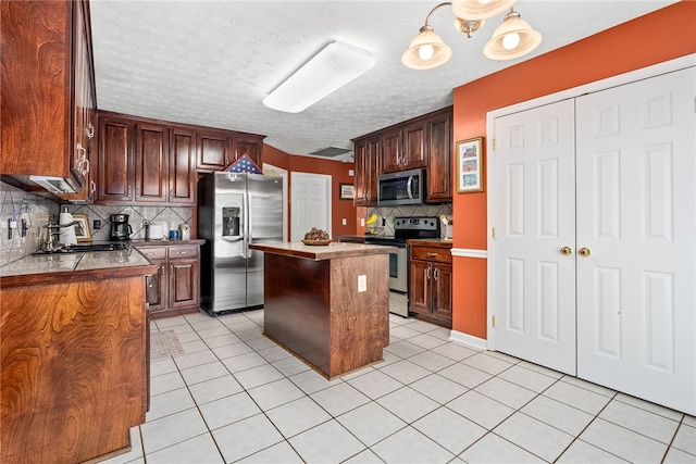 kitchen with stainless steel appliances, backsplash, a textured ceiling, a kitchen island, and sink