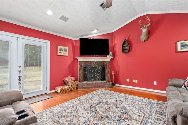 living room featuring a textured ceiling, crown molding, hardwood / wood-style floors, and vaulted ceiling