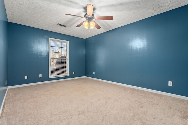 carpeted spare room featuring ceiling fan and a textured ceiling