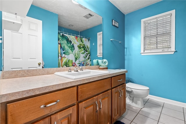 bathroom with toilet, vanity, tile patterned floors, and a textured ceiling