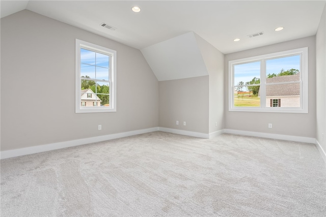 bonus room featuring light carpet, plenty of natural light, and visible vents