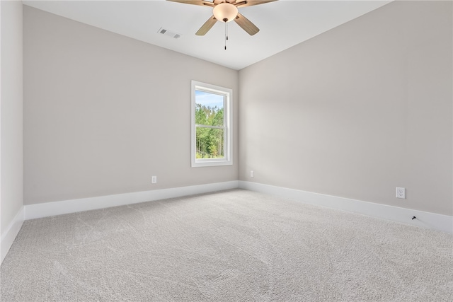 carpeted spare room with ceiling fan, visible vents, and baseboards