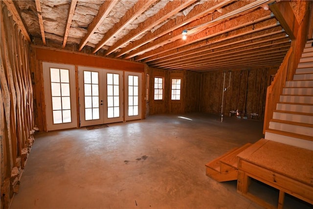 misc room with stairs and unfinished concrete flooring