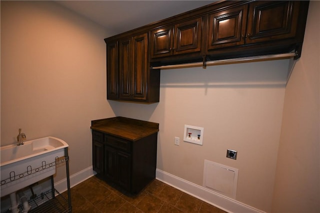 clothes washing area featuring cabinet space, hookup for a washing machine, electric dryer hookup, and baseboards