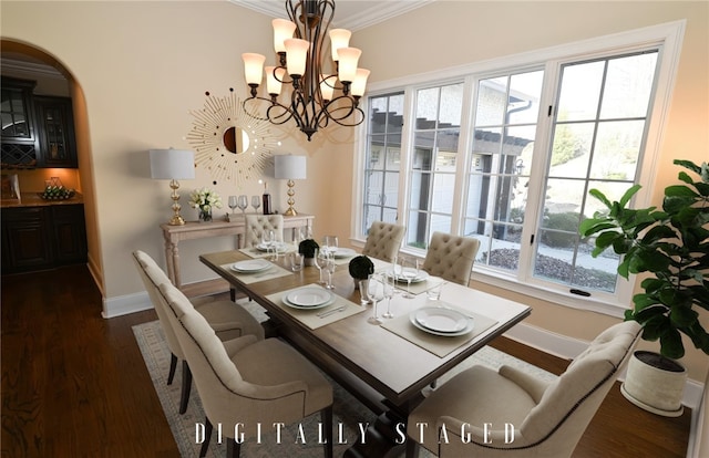 dining area featuring dark wood finished floors, crown molding, baseboards, and an inviting chandelier