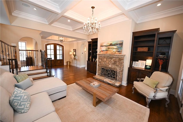 living room featuring a chandelier, french doors, coffered ceiling, and stairs