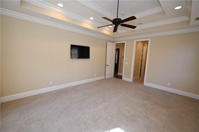 spare room featuring recessed lighting, carpet flooring, a raised ceiling, and baseboards