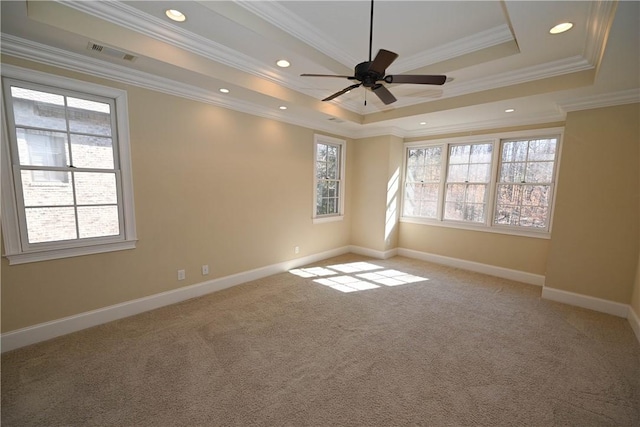 carpeted empty room featuring baseboards, visible vents, ornamental molding, a tray ceiling, and recessed lighting