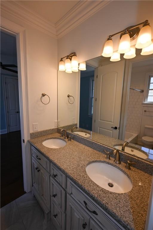 full bathroom featuring vanity, toilet, shower / bath combo with shower curtain, and ornamental molding