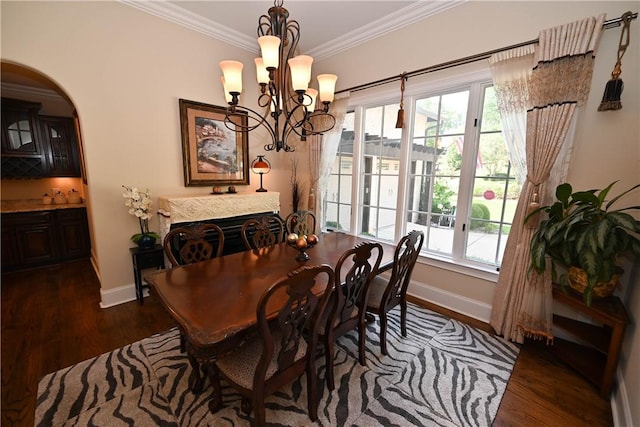 dining room with dark hardwood / wood-style floors, a healthy amount of sunlight, and ornamental molding