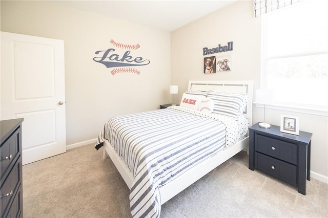bedroom featuring light colored carpet and baseboards