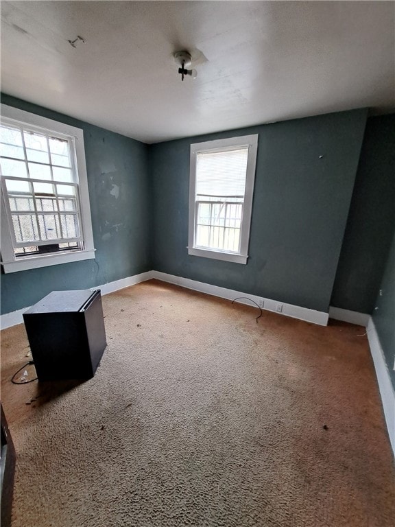 carpeted spare room with baseboards