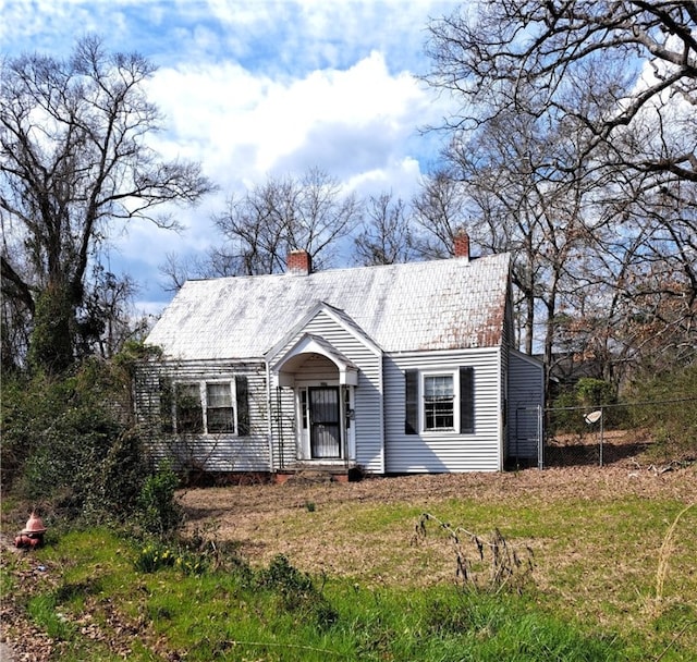 view of front facade featuring fence and a chimney