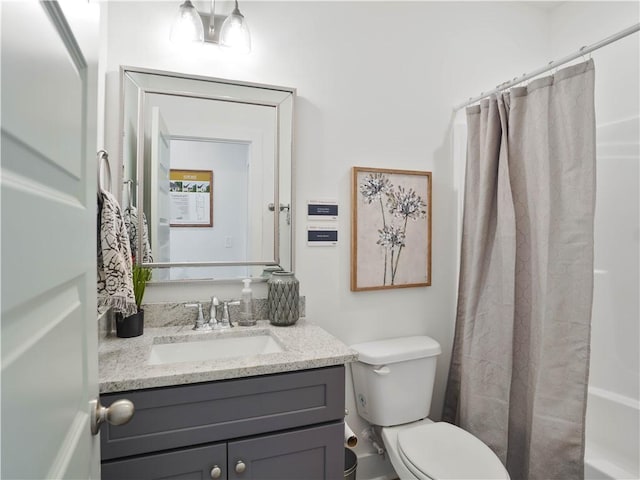 full bathroom featuring vanity, shower / bath combo with shower curtain, and toilet