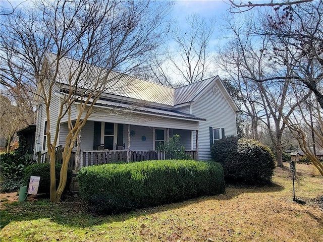 view of property exterior with covered porch and metal roof