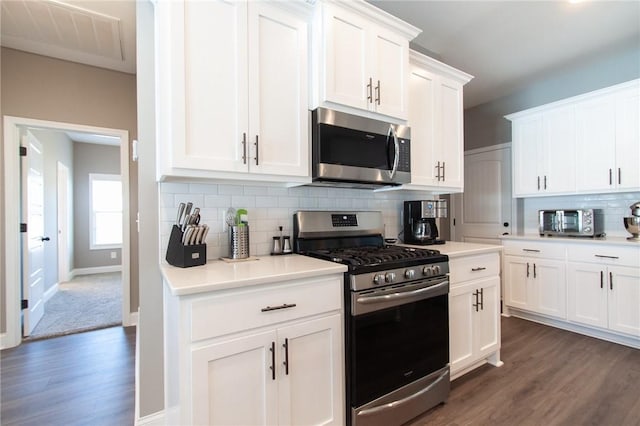 kitchen featuring white cabinets, tasteful backsplash, stainless steel appliances, and dark wood-style flooring