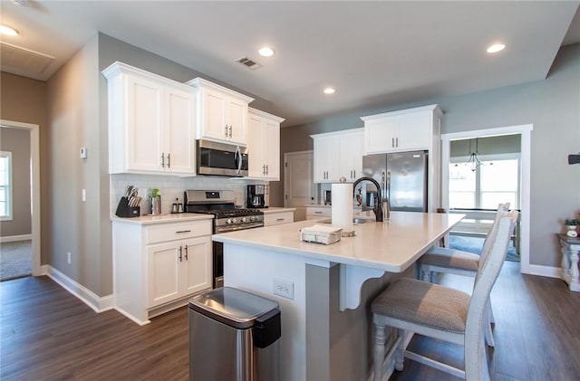 kitchen featuring tasteful backsplash, appliances with stainless steel finishes, visible vents, and a healthy amount of sunlight