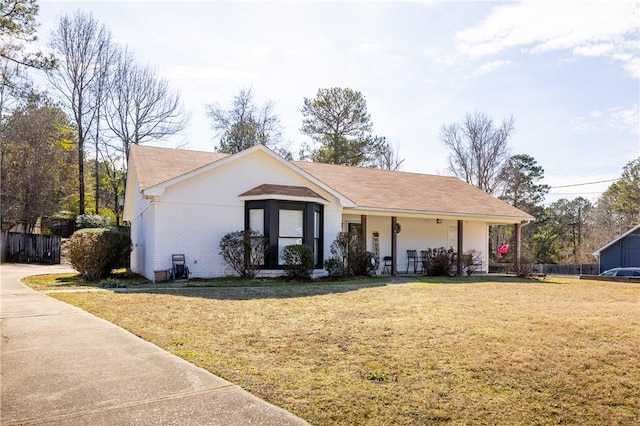 single story home with covered porch and a front yard