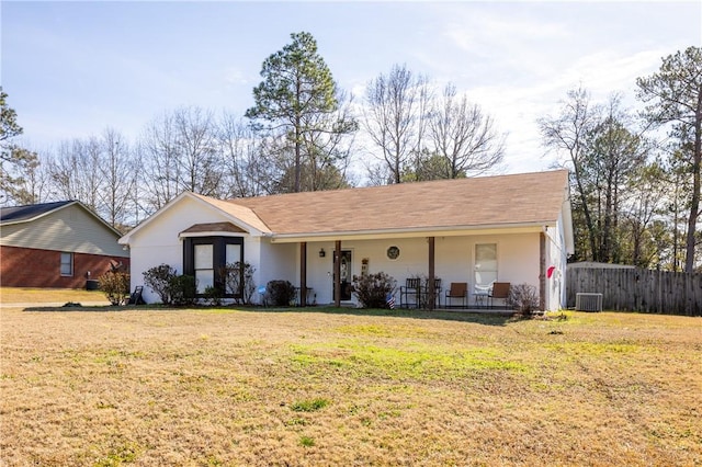 ranch-style home featuring cooling unit, a front lawn, and covered porch