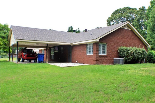 50 Cricket Rdg, Tallassee, AL 36078 - rear view of house featuring brick siding, a lawn, a carport, and central AC