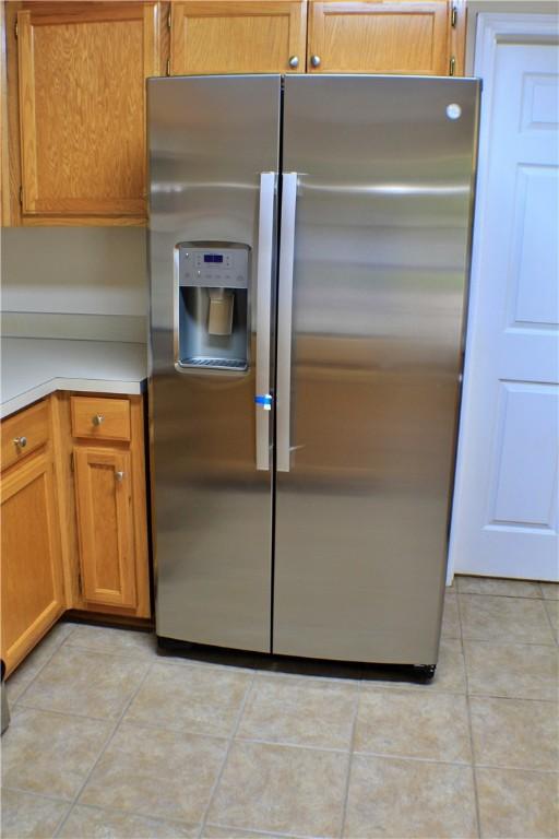 50 Cricket Rdg, Tallassee, AL 36078 - kitchen with stainless steel refrigerator with ice dispenser, light countertops, light tile patterned floors, and brown cabinetry