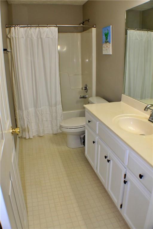 50 Cricket Rdg, Tallassee, AL 36078 - bathroom featuring toilet, vanity, shower / bathtub combination with curtain, and tile patterned floors