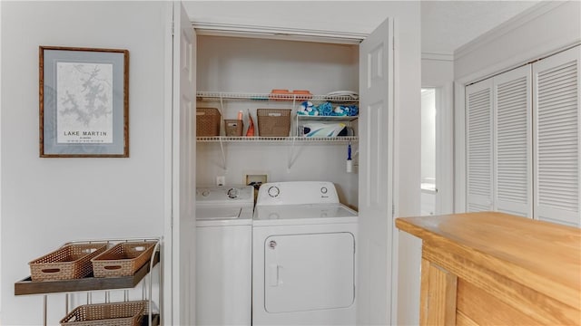 clothes washing area with separate washer and dryer and ornamental molding