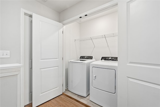 washroom featuring light wood finished floors, laundry area, and independent washer and dryer