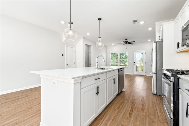 kitchen with visible vents, light wood-type flooring, appliances with stainless steel finishes, white cabinetry, and a sink