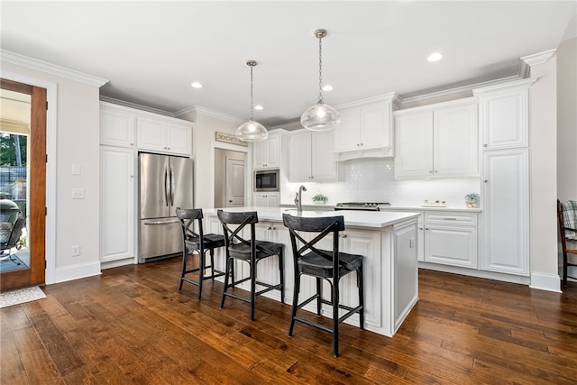 554 Arbor Dr, Auburn, AL 36830 - kitchen featuring stainless steel appliances, an island with sink, light countertops, a breakfast bar, and dark wood-style floors