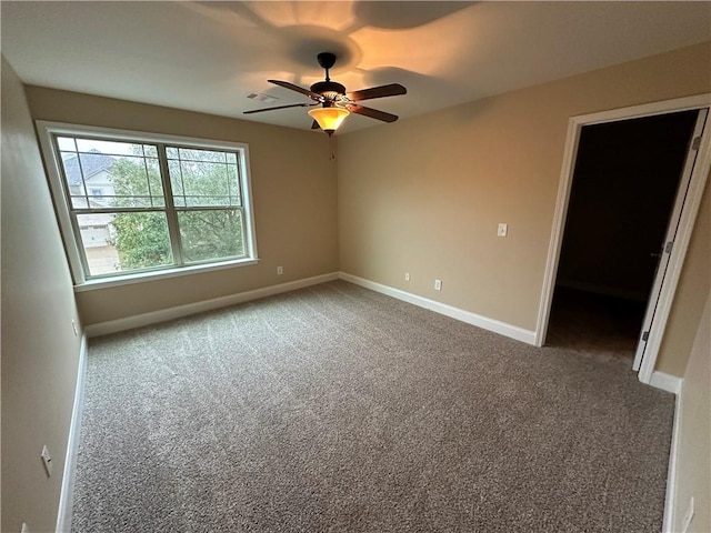 carpeted spare room with ceiling fan