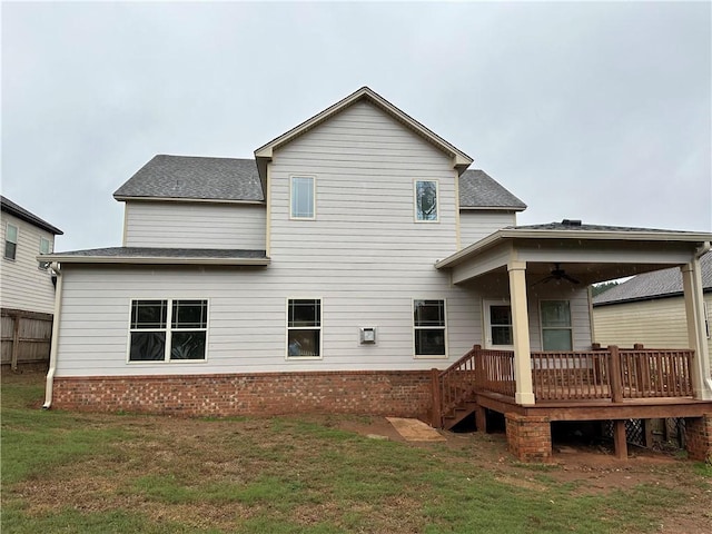 rear view of property with ceiling fan, a lawn, and a wooden deck