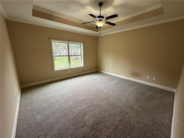 carpeted empty room with a tray ceiling, ceiling fan, and crown molding