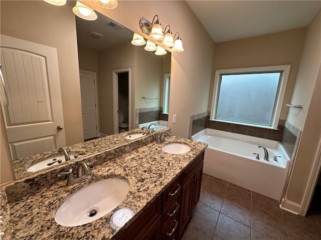 bathroom featuring a tub to relax in, tile patterned floors, vanity, and toilet