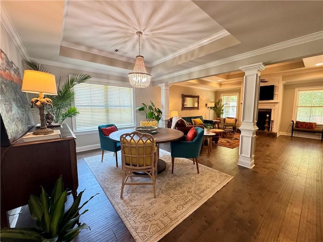 2457 Snowshill Ln, Auburn, AL 36832 - dining room with decorative columns, a raised ceiling, a fireplace with raised hearth, dark wood finished floors, and a chandelier
