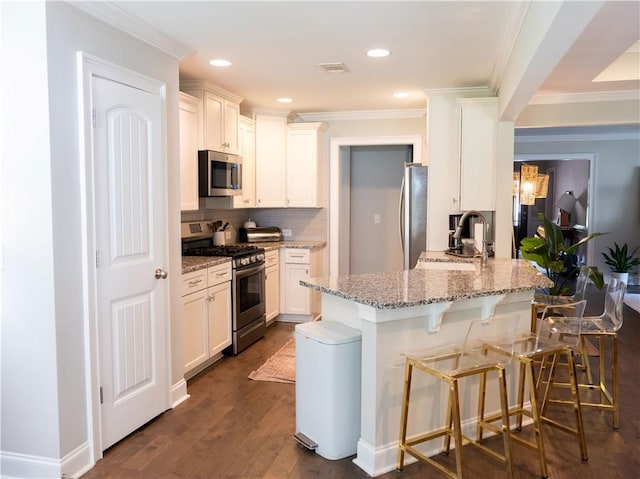2457 Snowshill Ln, Auburn, AL 36832 - kitchen with appliances with stainless steel finishes, a sink, a peninsula, ornamental molding, and a kitchen breakfast bar