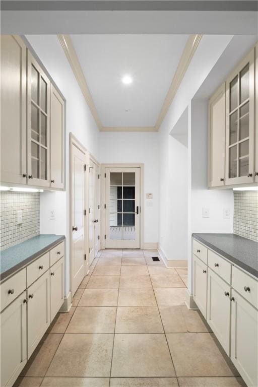 kitchen with light tile patterned floors, tasteful backsplash, and crown molding