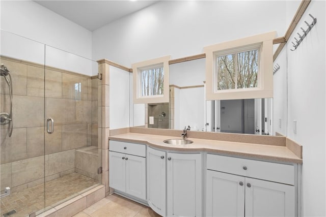 bathroom with tile patterned flooring, vanity, and walk in shower