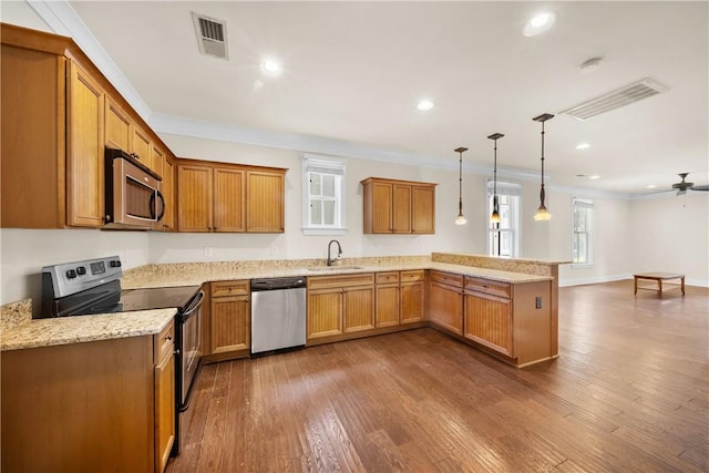 650 Dekalb St Unit 1130, Auburn, AL 36830 - kitchen with appliances with stainless steel finishes, crown molding, a peninsula, brown cabinetry, and dark wood-type flooring