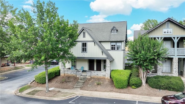 650 Dekalb St Unit 1130, Auburn, AL 36830 - view of front of property featuring stone siding, uncovered parking, covered porch, and a shingled roof