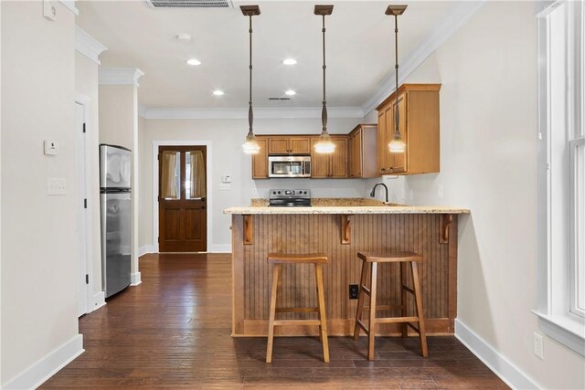 650 Dekalb St Unit 1130, Auburn, AL 36830 - kitchen featuring appliances with stainless steel finishes, ornamental molding, brown cabinets, a peninsula, and dark wood-style floors